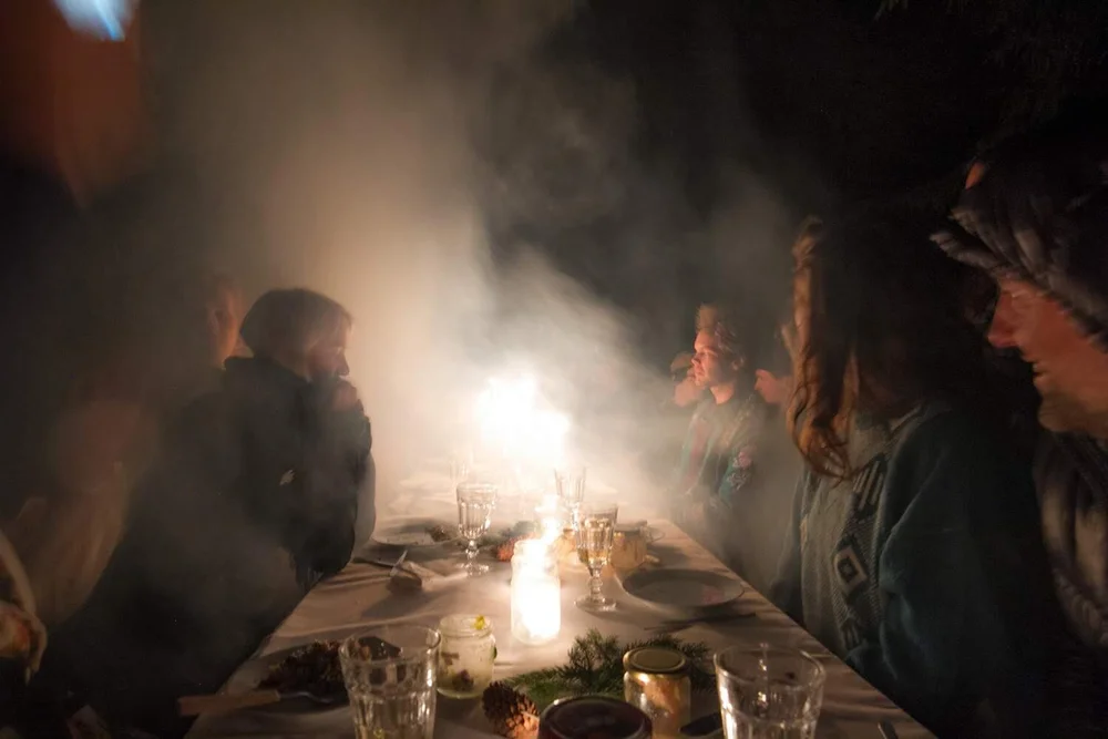 Participants around a steaming table during a shared meal