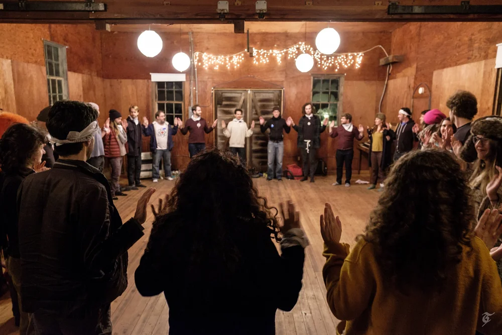 Participants in a circle in a barn at night